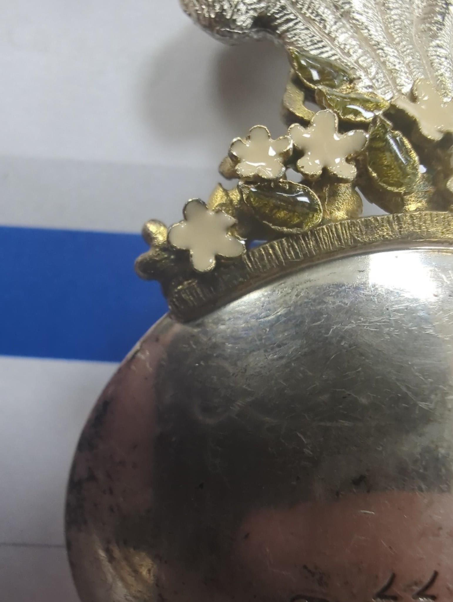 A Queen Elizabeth II parcel gilt silver and enamel caddy spoon, by Stuart Devlin, the handle modelled as the Prince of Wales feathers, London,1982, 68mm, numbered 77.